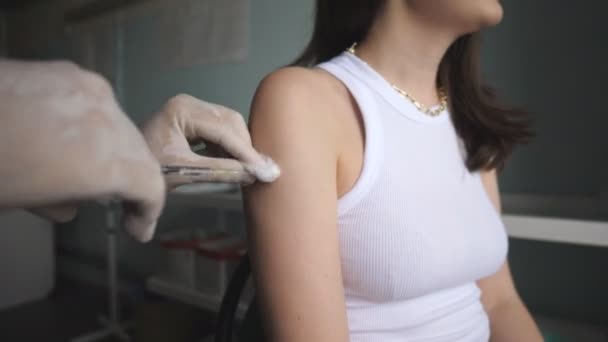 Hemşire, Covid-19 ya da grip aşısı aşısını sağlık kliniğindeki kadın hastaya yapıyor. Güvenlik eldiveni takmış bir doktor hastaya aşı enjekte ediyor. Dokunulmazlık uyarma kavramı — Stok video