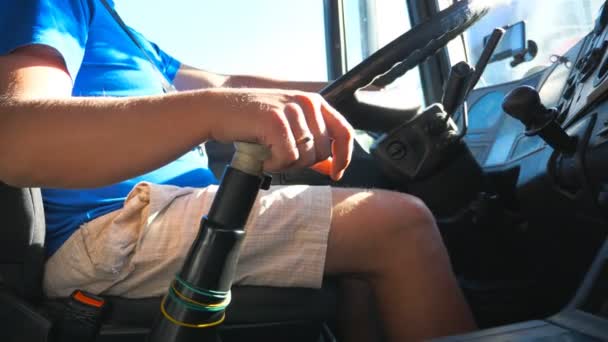 Vista bassa del conducente irriconoscibile seduto al volante del suo camion e in viaggio su strada di campagna. L'uomo che controlla il suo camion che guida fino a destinazione nella giornata di sole. Colpo interno Rallentatore Close up — Video Stock