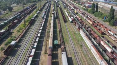 Endüstriyel demiryolu terminalinde yük vagonları ve konteyner trenlerinin hava görüntüleri. Tren istasyonunda yük vagonlarının üzerinde uçuyorlar. Ulaşım ya da teslimat konsepti. Nakliye malları. Üst görünüm