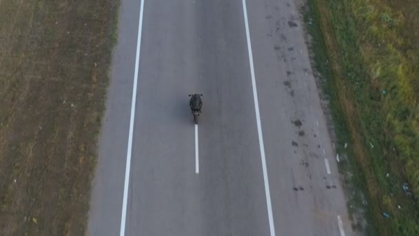 오토바이를 타고 시골길을 질주하는 오토바이 운전자의 공중 샷. 현대의 스포츠카 오토바이를 타고 고속도로를 달리는 남자. 여행중에 자전거를 운전하는 남자. 자유와 모험의 개념. 위에서 본 풍경 — 비디오