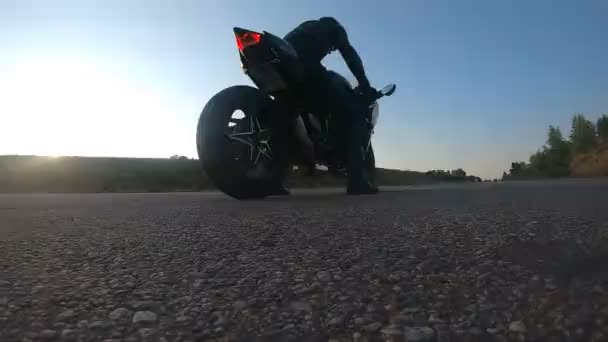 Motociclista realizando burnout pneu com muita fumaça. Roda de moto esporte começando a girar na estrada de asfalto. Motocicleta inicia o movimento. Conceito de acrobacias e estilo de vida. Lento movimento Fechar — Vídeo de Stock