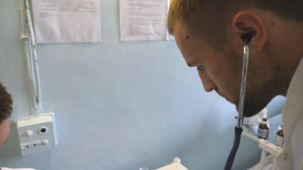 Чоловік-лікар перевіряє кров'яний тиск на молодого чоловіка. Вимірювання пульсу для пацієнта. крупним планом — стокове відео