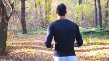 Orman yolunda koşan tanınmayan bir adam. Erkek sporcu doğada çalışıyor. Güçlü ve dayanıklı bir sporcu dışarıda kardiyo eğitimi alıyor. Aktif yaşam tarzı konsepti. Arka plan