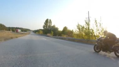 Güneşli bir sonbahar gününde otoyolda motosiklet süren bir bisikletçi. Motosikletli, kır yolunda motosikletiyle yarışıyor. Yolculuk sırasında bisiklet süren bir adam. Özgürlük ve macera kavramı. Hava görüntüsü