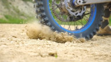 Güçlü off-road motorsiklet çarkını kapat. Dönüyor ve kuru zemini veya tozu tekmeliyor. Profesyonel motokros sürücüsü yarışı başlatıyor. Motor sporu ya da aktif yaşam tarzı kavramı. Dolly vurdu.