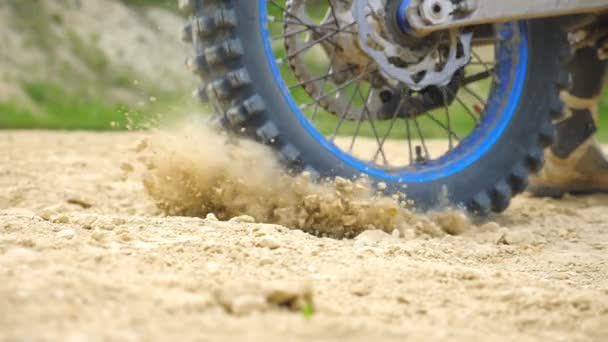 Cerca de la rueda de la motocicleta todoterreno de gran alcance girando y pateando el suelo seco o polvo. Carrera de motocross profesional. Concepto de automovilismo o estilo de vida activo. Dolly disparó — Vídeos de Stock