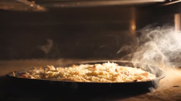 Deliciosa pizza de cuatro quesos se hornea en el horno eléctrico en el restaurante de la cocina. Mozzarella, cheddar, parmesano y feta fusión en horno a alta temperatura. Proceso de preparación de alimentos. De cerca. — Vídeo de stock
