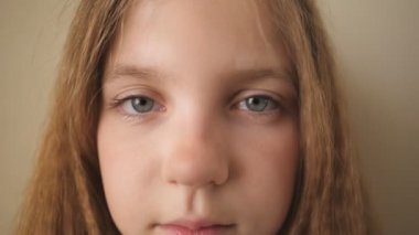 Kapalı mekandaki kameraya bakan çaresiz çocuğun kadın yüzünü kapatın. Üzgün küçük bir çocuğun hayal kırıklığına uğramış bakışları. İçinde hüzünlü bir ifade olan küçük sarışın kızın portresi.
