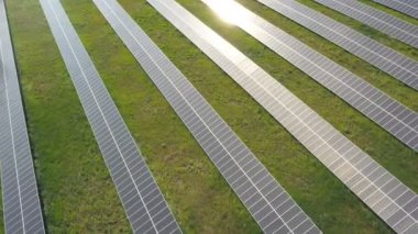 Çayıra kurulmuş ve elektrik üreten güneş enerjisi istasyonunun hava görüntüsü. Güneş çiftliğinin en üst görüntüsü, yüzeyde güneş yansımaları var. Modern yenilenebilir yeşil enerji. Ekoloji kavramı