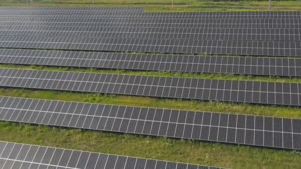 Zdjęcie lotnicze rzędów paneli słonecznych zainstalowanych na łące i generujących energię elektryczną. Czysta ekologia przyjazna energia ze słońca. Koncepcja nowoczesnej odnawialnej zielonej energii. Widok z góry zbliżenie — Wideo stockowe