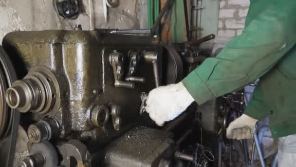 Réparateur dans des lunettes de protection utilise un tour de traitement du métal en atelier. Mécanicien masculin en uniforme travaillant sur un vieil établi dans son garage. Travail sur fraiseuse sur le lieu de travail. Tir de grue — Video
