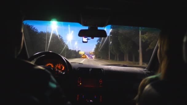 Молодая пара сидит на переднем сиденье внедорожника и едет по пустой дороге. Вечером мужчина и женщина едут на современном автомобиле. Девушка и парень переезжает в автомобиле на шоссе в ночное время — стоковое видео