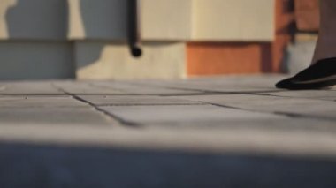 Yüksek topuklu siyah ayakkabılı zayıf kadın bacakları kaldırıma çıkıyor. Yüksek topuklu ayakkabılı kağıt paketlerle şehir merkezine giden bir kız. Genç bir kadın alışveriş torbalarını şehir caddesinde gezdiriyor.