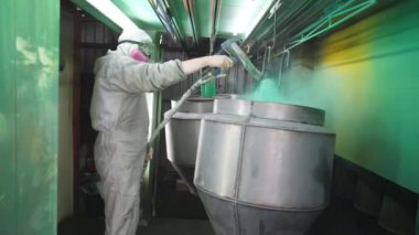 Endüstriyel boyama odası. Boyacı özel bölmede detaylara yeşil boya sıkıyor. Endüstriyel imalatta güvenlik görevlisi. Uzman atölyede ana boya parçaları.