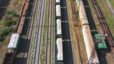 Endüstriyel demiryolu terminalinde yük vagonları ve konteyner trenlerinin hava görüntüleri. Tren istasyonunda yük vagonlarının üzerinde uçuyorlar. Ulaşım ya da teslimat konsepti. Nakliye malları. Üst görünüm