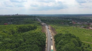 Yenilenme kırsal otobanındaki trafik akışının hava görüntüsü. İHA yol çalışması sırasında asfalt otoyol boyunca giden arabaların üzerinde uçuyor. Etrafı güzel manzaralı kırsal bölgelerde dolaşan otomobiller. Üst görünüm.