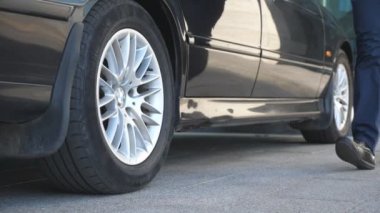 Sürücü arabaya geliyor ve iş adamına kapıyı açıyor. Şoför, erkek yolcular için otomobilin kapısını açtı. İşadamı arabadan indi ve ofis binasına gitti. Yavaş Hareket.