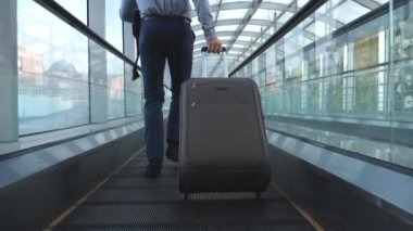 Bacaklar terminal salonunda çalışan ve bavul tekerlekleri çekerek başarılı iş adamı. Kamera takip onun Bagaj ile genç adam için uçuş için geç oldu. Adam acele iş gezisi için. Yavaş mo yakın çekim.