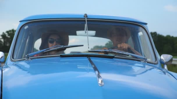 Młoda Uśmiechnięta Para Kapeluszach Jadąca Zabytkowym Samochodzie Podczas Letnich Podróży — Wideo stockowe