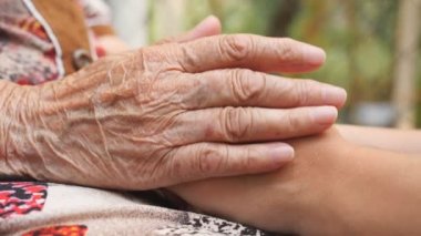 Dışarıda genç bayanların kollarını okşayan yaşlı kadınların eli. Torunumla büyükannem dışarıda vakit geçiriyorlar. İlgi ve sevgi kavramı. Yan Görünümü Kapat Yavaş Çekim.