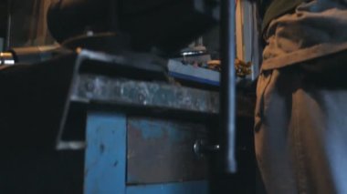 Tamirci, araç parçalarını araç kullanarak onarıyor. Çalışan adam garajda ya da atölyede çalışıyor. Sıkı çalışma konsepti. Arka plan Yavaş çekim Kapat.