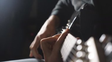 Dizeleri, gitarist parmakları kapatın. Mens çalış solo rock müzik silah. Eller erkek müzisyen elektro gitar çalmak. Stüdyoda güzel siyah arka plan. Ağır çekim yakın çekim.