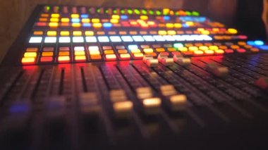 Close up of dj remote or soundboard with moving buttons and brightly glow keys. Working process on recording studio. Amplifier and balance of sound. Musical player at party in night club. Slow motion.