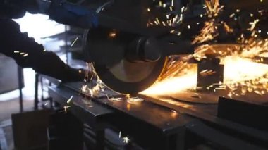 Testere kesme makinesi metali kesiyor. Birçok parlak kıvılcım sıcak metalden uçar. Garajda ya da atölyede çeliği kesen dairesel testere. Endüstriyel profesyonel imalatta öğütülen metal. Yavaş çekim.