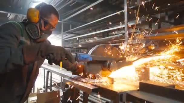 장인은 작업장에서 디스크 분쇄기로 금속을 톱질합니다 차고에서 강철을 노동자가 금속을 — 비디오