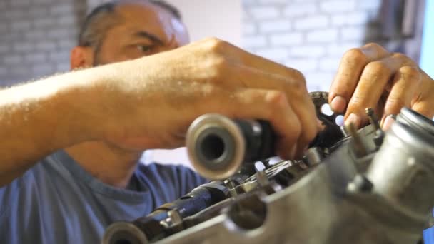 专业机修工修理汽车上的马达 汽车主修理摩托车发动机在车库里或车间 戴胡子的人雇用维修汽车或摩托车 特写慢动作 — 图库视频影像