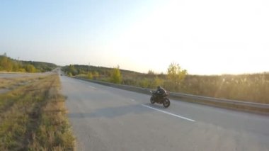 Güneşli bir sonbahar gününde otoyolda motosiklet süren bir bisikletçi. Motosikletli, kır yolunda motosikletiyle yarışıyor. Yolculuk sırasında bisiklet süren bir adam. Özgürlük ve macera kavramı. Hava görüntüsü