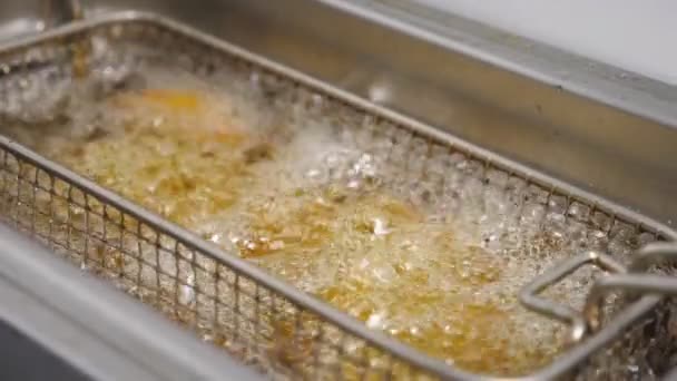 クリスピーフライドポテトはキッチンで揚げ物を作っています 素朴なジャガイモのおいしいスライスは熱い沸騰油で揚げています 料理でファーストフードを作るプロセス 食べ物の準備の概念 トップ表示 — ストック動画