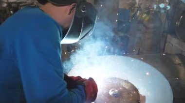 Kaynakçı metal işleriyle uğraşır. Endüstriyel üretimde koruyucu maske kaynak işçisi. Çelik gibi ağır işçilik. Erkek, ağır iş. Garajda veya metal fabrikasında çalışan bir zanaatkar..