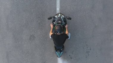 Motosikletlinin lastikleri patlatırken çok duman çıkıyor. Hareket başladığında motosiklet tekeri yolda kayıyor. Spor motosiklet çarkı asfalt yolda dönmeye başlar. Yavaş çekim Havadan çekim.