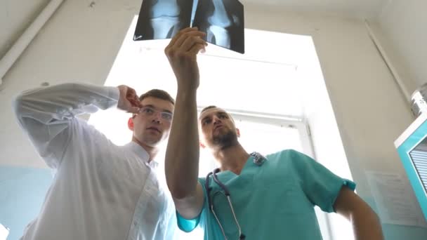 Erkek Doktorlar Röntgen Görüntülerine Bakarken Birbirlerine Danışıyorlar Kafkasyalı Iki Doktor — Stok video