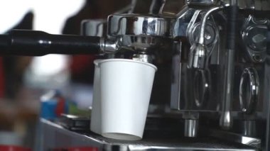 Profesyonel kahve makinesinden alınan doğal sert kahvenin hazırlanışına bakın. Kadın barista filtre tutacağı kullanarak taze aromatik içecek yapıyor. Şehir kafesinde çalışma süreci. Yavaş çekim. Yakın çekim..