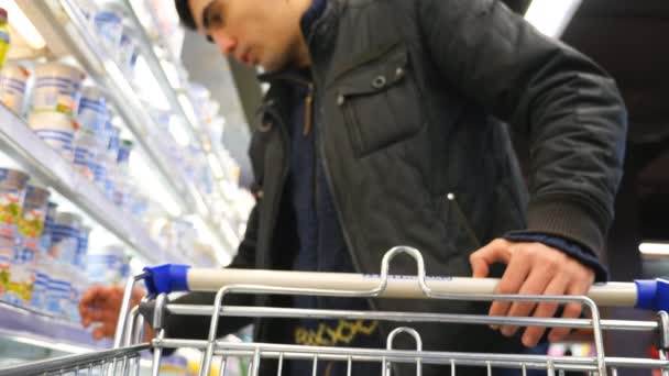 Mann Mit Einkaufswagen Steht Neben Vitrine Supermarkt Guy Wählt Waren — Stockvideo