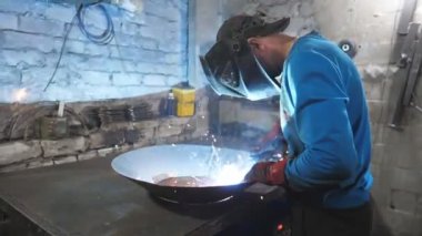 Kaynakçı metal işleriyle uğraşır. Endüstriyel üretimde koruyucu maske kaynak işçisi. Çelik gibi ağır işçilik. Erkek, ağır iş. Garajda veya metal fabrikasında çalışan bir zanaatkar..