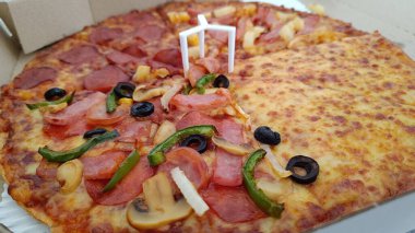 Yan görünüş, pizza, peynir, jambon, sosis, biber, soğan ve baharat..