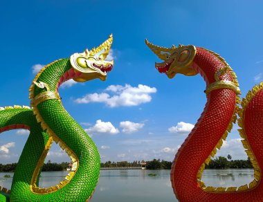 Chachoengsao Tayland Ocak 132022: Gökyüzünün arka planında büyük Naga yeşil ve turuncu heykeli ve Wat Saman Rattanaram tapınağında bulut