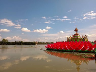 Chachoengsao Tayland Ocak 132022: Bang Pakong Nehri 'nin ortasında pembe nilüfer üzerinde Buda heykeli ve Saman Rattanaram Tapınağı' ndaki bulutlar