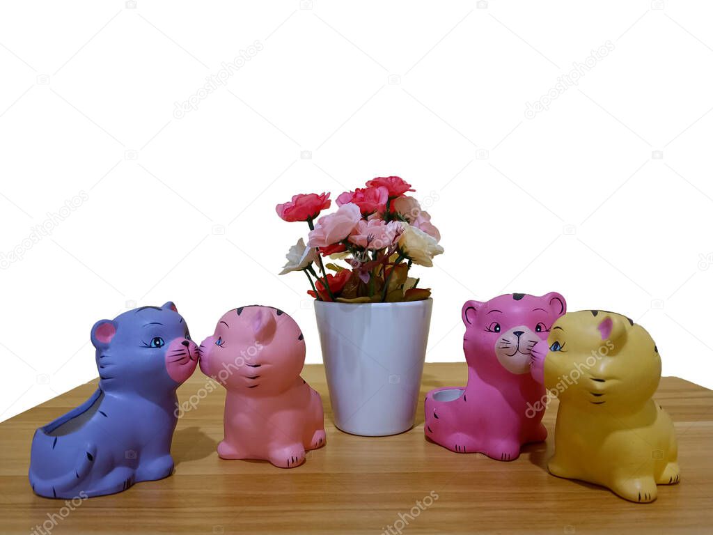 Small plastic colorful cat figures built and flower on table