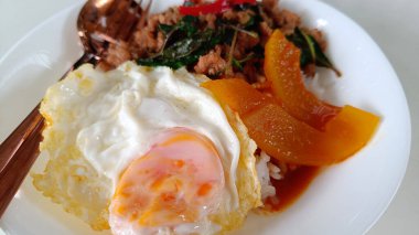 Tayland yemeği, kızarmış yumurta, pilav, kızarmış domuz, baharat, fesleğen ve körili Benincasa Hispida beyaz tabağı.