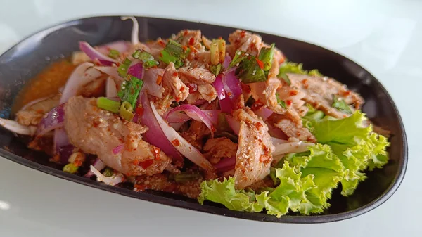 Tayland yemeği kızartılmış domuz salatası ya da nane yaprağı ve kurutulmuş acılı Vietnam Tok garnitürü. Nam Tok baharatlı Kuzeydoğu yemekleri.