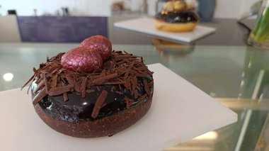 Duble çikolatalı çörekler ve beyaz tabakta kırmızı paskalya yumurtalarıyla süslenmiş.