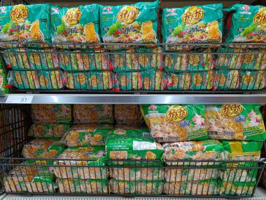 Nonthaburi, Tayland - 20 Nisan 2022: Popüler Tayland eriştesi YUM YUM bir markette veya süpermarket rafında satılmaktadır. Düşük maaşlı yiyecekler ve pahalı yaşam masraflarıyla tanınır.