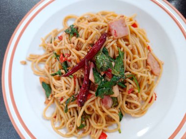 Baharatlı domuz ve fesleğenli spagetti. Tayland füzyon yiyeceği.