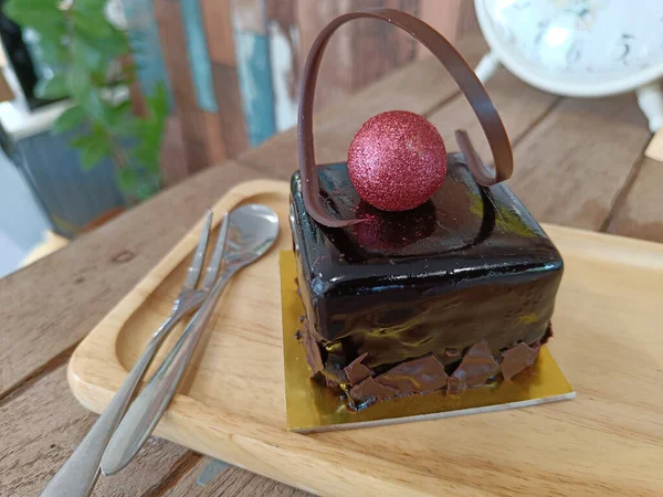 Çikolatalı cheesecake. Adı Tia Maria. Ahşap bir tabakta, arka planda.