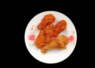 Siyah arka planda, tabakta kızarmış tavuk kanadı..