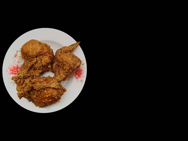 Crispy fried chicken on plate, on black background with copy space